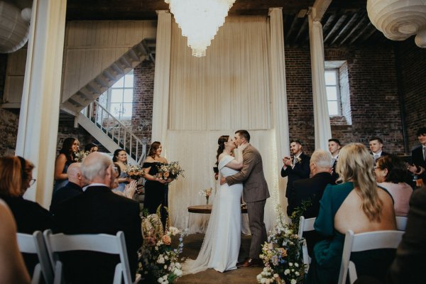 Bride with groom at alter priest ceremony kiss kissing