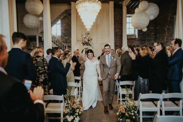 Bride and groom exit ceremonial room flowers in the air