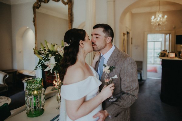 Bride and groom kiss kissing champagne wine glass in hand