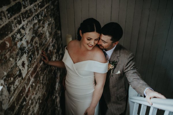 Groom kisses bride on neck close hugging