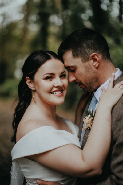 Bride and groom pose for a photo exterior shot