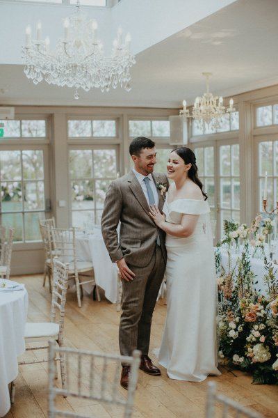 Bride and groom in the dining room chandelier hanging above