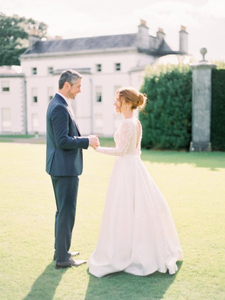 Bride and groom on grass outside venue