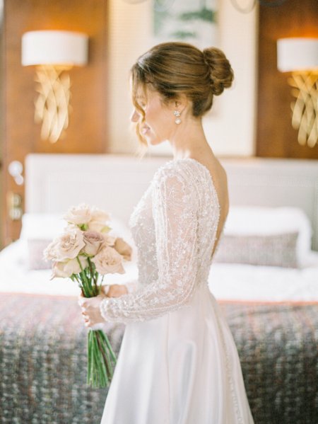 Bride interior getting ready holding flowers