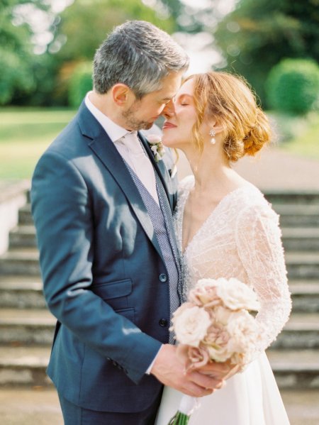 Bride holding Pink white roses flowers bouquet groom kiss