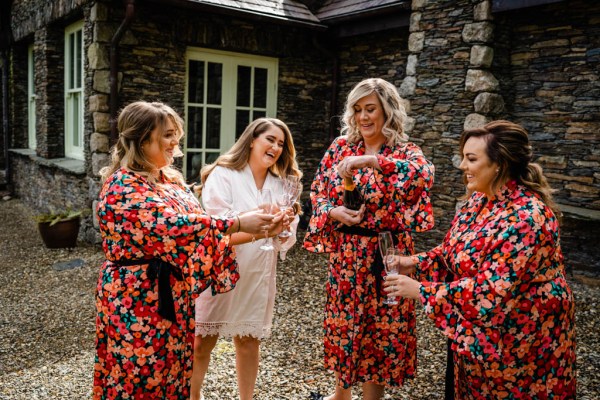 Bridesmaids red floral flowers holding flowers opening champagne prosecco