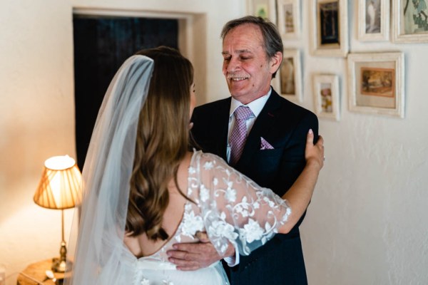 Shot of bride from behind hugging father veil detail