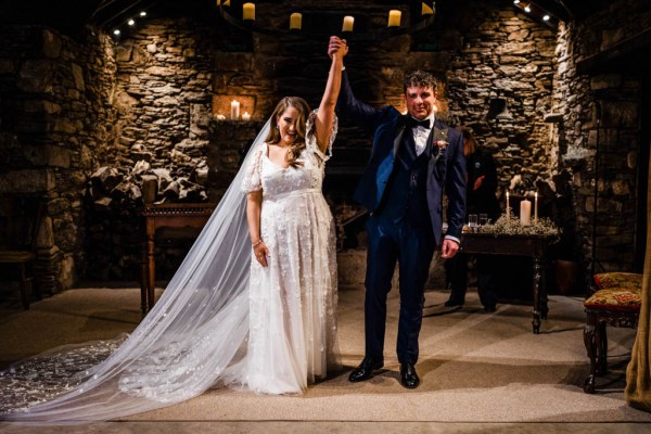 Bride and groom just wed ceremonial room hand in the air alter church