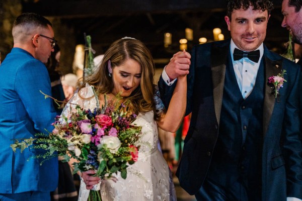 Bride and groom exit ceremonial room together flowers in hand