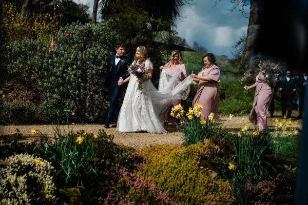 Bride and groom bridesmaid holding train bridal gown dress forest park