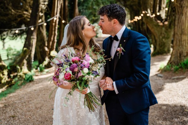 Bride and groom standing in park forest together