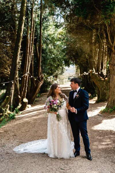 Bride and groom standing in park forest together