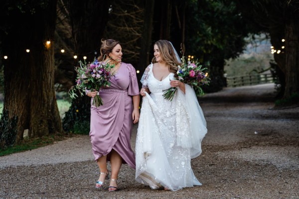 Bride and bridesmaid walking with flowers in hand