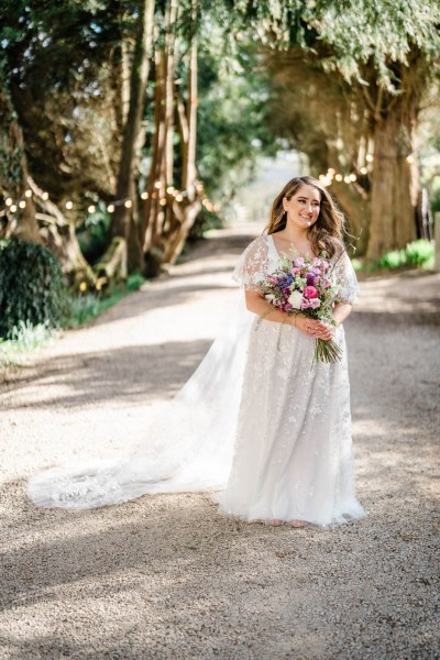 Bride on her own holding bouquet flowers smiling laughing