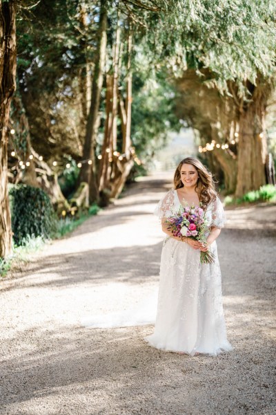 Bride on her own holding bouquet flowers smiling laughing