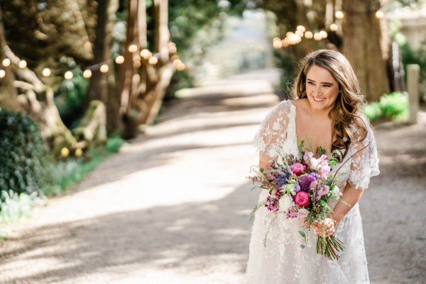 Bride on her own holding bouquet flowers smiling laughing