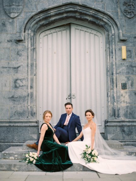 Groom bride and mother sitting on the steps