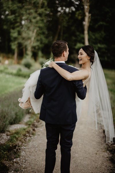 Groom carrying bride on pathway