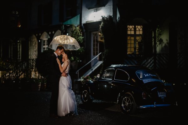 Bride and groom holding umbrella