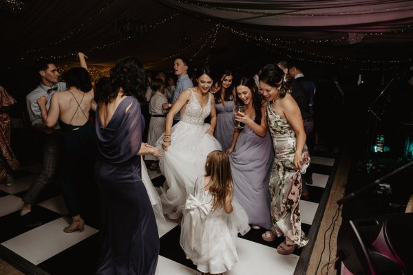 Bride and little girl dancing on dancefloor