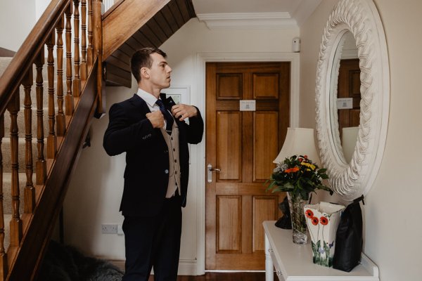 Groom getting ready suit and tie before wedding ceremony