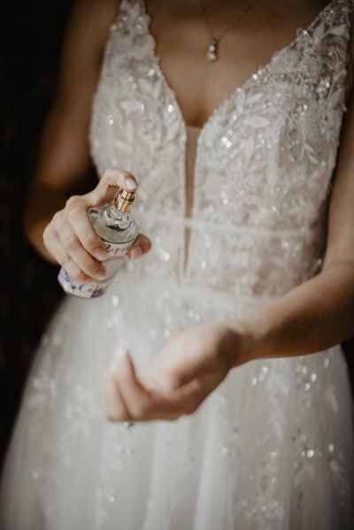 Bride putting on perfume