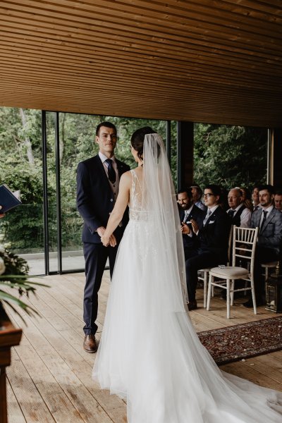 Bride and groom hand in hand at alter