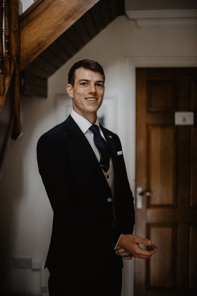 Groom getting ready suit and tie before wedding ceremony