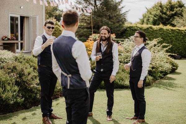 Groom and groomsmen drinking champagne wine