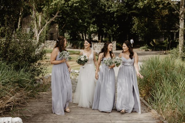 Bride and bridesmaids in park forest