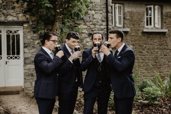 Groom and groomsmen drinking Guinness ale alcohol