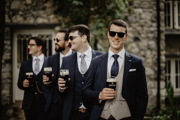 Groom and groomsmen drinking Guinness ale alcohol