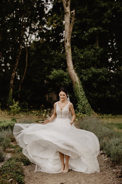 Bride running through park on pathway