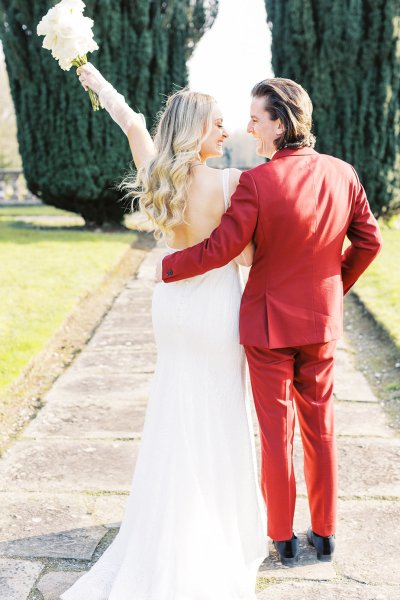 Groom and bride holding each other in park