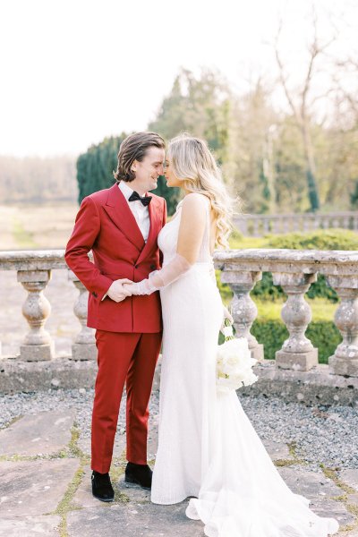 Groom and bride holding each other in park