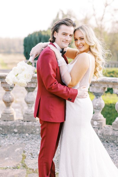 Groom and bride holding each other in park