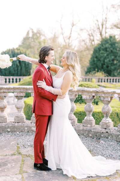 Groom and bride holding each other in park