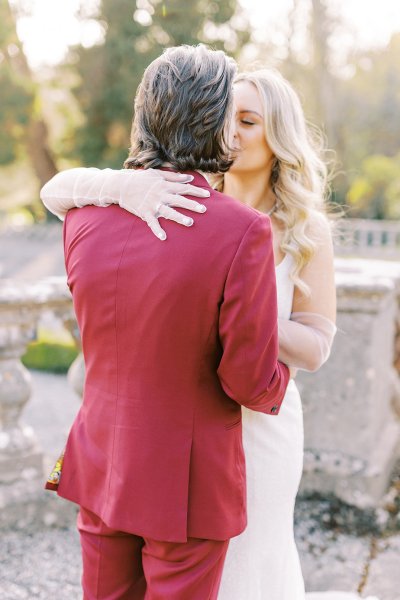 Groom and bride holding each other in park kissing kiss