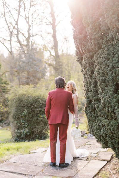 Groom and bride holding each other in park