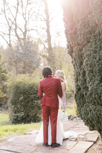 Groom and bride holding each other in park