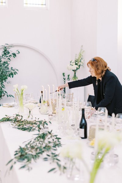 Woman pouring prosecco into glasses on table