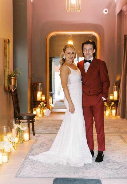 Groom in red suit bride interior candles lighting