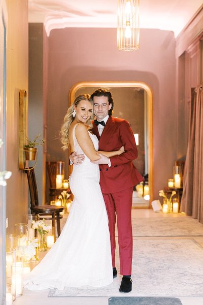 Groom in red suit bride interior candles lighting