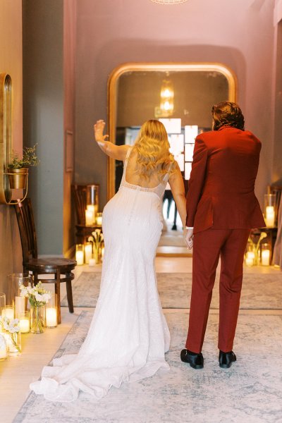 Groom in red suit bride interior candles lighting