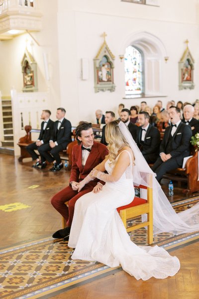 Bride and groom with guests in background