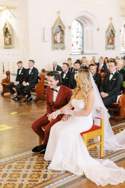 Bride and groom with guests in background