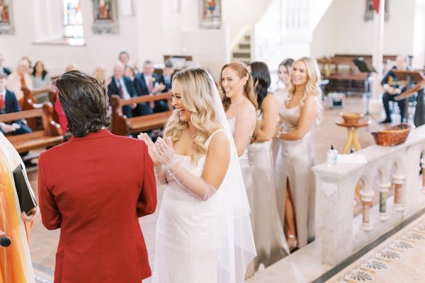 Bride and groom with guests in background laughing