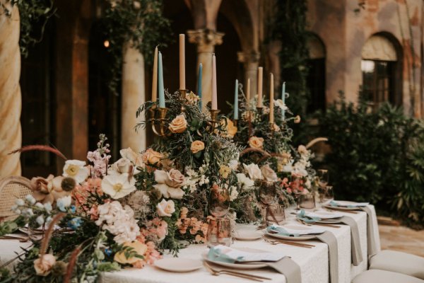 Table decor pink white roses flowers candles cutlery and wine glasses candles exterior shot