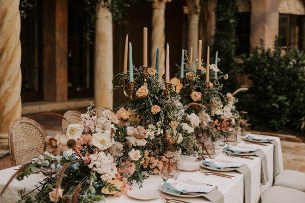 tablescape floral centrepiece Table decor pink white roses flowers candles cutlery and wine glasses candles