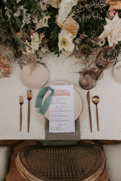 Table setting with cutlery and menu and flowers roses